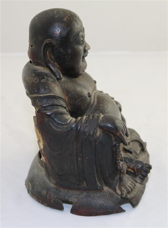 A Chinese gilt lacquered bronze seated figure of Budai, late Ming dynasty, 17cm, damage